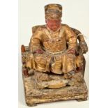 A Chinese mid 19th century wood carving of a house god in the form of an emperor seated upon a