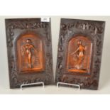 A pair of carved fruitwood panels showing ladies in medieval style and carved oak frames, 30.5 x 13.