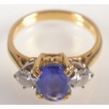 An 18ct. yellow gold ring set an oval amethyst flanked by diamonds.