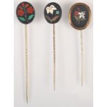 Three pietra dura pins, one with a gold mount.
