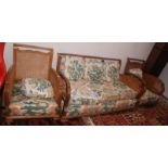 A walnut bergere three seat art deco sofa and a pair of matching armchairs.