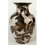 A Chinese porcelain baluster vase, the black ground gilt decorated with cranes in flight,