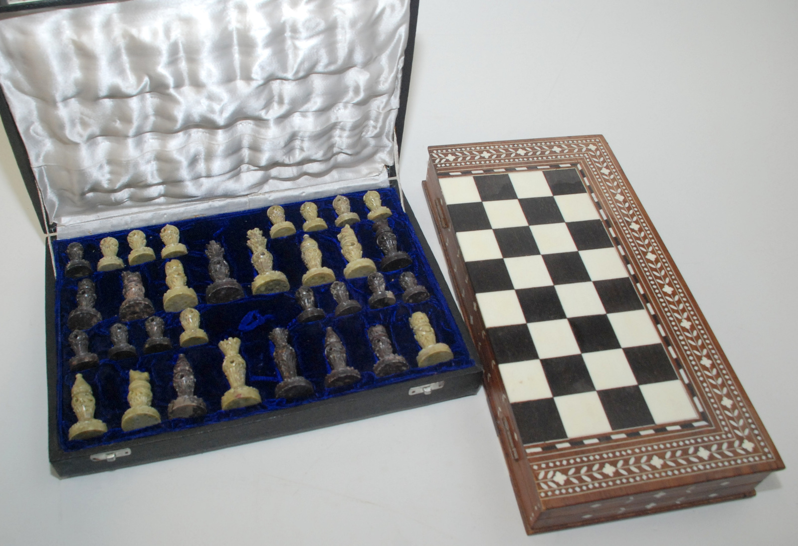 An Indian inlaid hardwood chess board/box and a soapstone chess set.