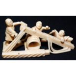 A Japanese ivory okimono, carved with three men at work, possibly carpenters. width 9.5cm.