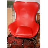 A stylish red leather swivel armchair.
