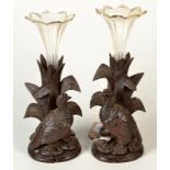 A pair of cut glass spills, each in a Black Forest stand, carved with a bird.