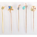 A gold turquoise and diamond floral pin and four other floral pins.