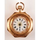 An octagonal cased 14ct. gold fob watch with ornate gilt dial.
