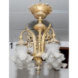 A cast brass four branch electrolier with glass shades, height 47cm.