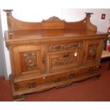 An Edwardian substantial carved oak sideboard with a three quarter gallery and Art Nouveau brass