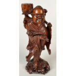 A Chinese carved hardwood figure of a man carrying a ceremonial spectre, height 34.5cm.