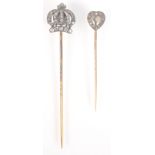 A gold pin, the finial a diamond set crown and a gold pin with diamond set heart finial.