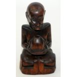 An eastern carved hardwood seated figure, height 29cm.