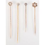 Four gold stick pins, each with a diamond, the largest approximately 0.4ct. spread.