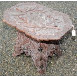 An Indian carved wood occasional table, the top with a pierced border and decorated with foliage,
