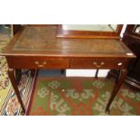 An early 20th century mahogany writing table with leather lined top, two frieze drawers,