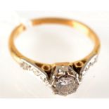 A solitaire diamond ring with diamond shoulders in 18ct. gold.