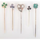 An English gold four leaf clover pin signed Johnson, the leaves green enamelled, at the centre,