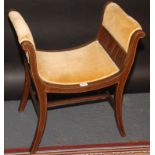 An Edwardian mahogany piano stool with upholstered arms and seat on splayed supports.