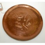 A Newlyn copper circular tray, repousee decorated with three fish and weed,
