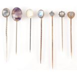 A blue john silver pin, a gold pin with moonstone heart finial and five other moonstone pins.