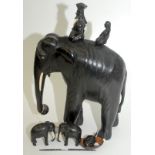 A large ebony elephant with two riders, together with two pairs of smaller ebony elephants.