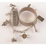A silver charm bracelet, a silver ingot and a silver napkin ring.