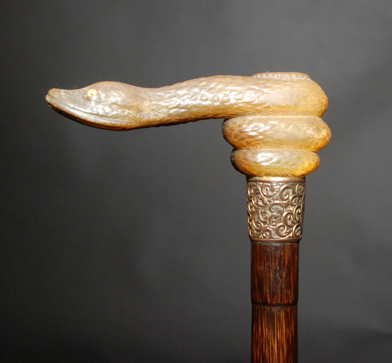 An late Victorian or Edwardian walking stick, the handle a coiled snake with glass eyes, length 93.