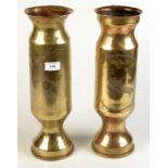 A pair of trench art brass shell case vases, one shows a woman standing by a lounge chair,