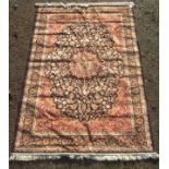 A Kashan design machine made carpet, the indigo field with a lobed pole medallion,