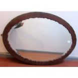 An oval, bevel edge, mahogany framed mirror.