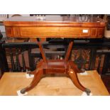 A Regency inlaid, foldtop card table on four sabre legs with lions paw feet, width 91.5cm.