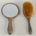 A silver mounted hand mirror and a silver mounted brush.