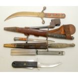 A Second World War fighting knife with cast handle and brown leather sheath,