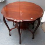 An Edwardian circular walnut centre table on cabriole legs joined by a low shelf, diameter 75.5cm.