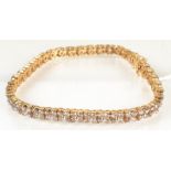 An 18ct gold and diamond bracelet with a line of quatrefoil flower heads each with a central white