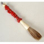 An oriental ivory and coral handled brush, length 25.5 cm.