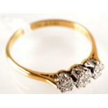 An 18 ct. gold illusion set three stone diamond ring.