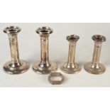 Two pairs of filled candlesticks, damage, and a napkin ring.