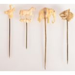 A gold mounted ivory elephant pin together with four other pins in carved ivory or bone.