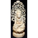 An Indian ivory figure of a god sitting crosslegged on a throne, 19th century, height 15cm.