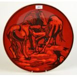 A Poole large shape 54 red ground saucer dish decorated with horses by Carole Holden, diameter 41.