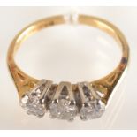 An 18 ct. gold three stone diamond ring.