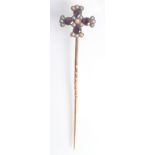 A pin with bottony cross finial this set with pear form flat cut garnets and seed pearls, boxed.