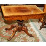 A Victorian walnut card table with cross banded fold top on carved pedestal and ornate quadruple