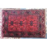 An Iranian rug, the madder field with three linked indigo medallions, plants and guls,