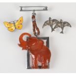 An 'amber' elephant fob and an enamel butterfly brooch and one other bird brooch.