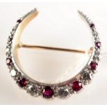 An alternating graduated ruby and diamond crescent brooch.