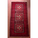 An Afghan rug, with three square medallions enclosing hooked guls,