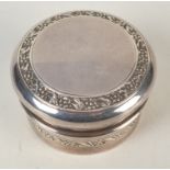 A silver cylindrical embossed toilet box.